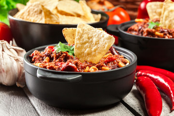 Bowls of hot chili con carne with ground beef, beans, tomatoes and corn