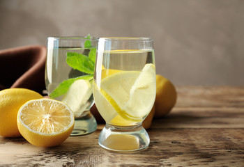 Composition with cold lemon water on wooden table