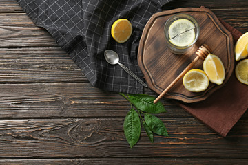 Fototapeta na wymiar Composition with cold lemon water on wooden table