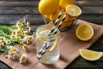 Composition with cold lemon water on wooden table, closeup