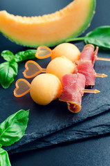 Naklejka na ściany i meble Colorful canape on skewers with melon and prosciutto