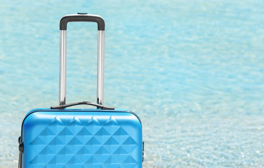 Packed suitcase and blurred sea on background. Vacation concept