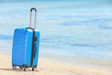 Packed suitcase at sea shore. Vacation concept