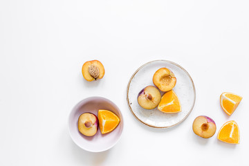 cut peach and orange for exotic fruit on plates white background top view mockup