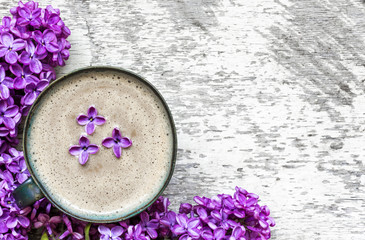 Obraz na płótnie Canvas morning cup of coffee with purple lilac flowers