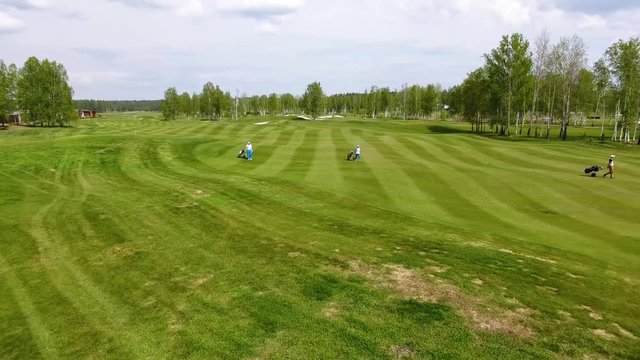 Aerial view Golf course. Golfers walking down the fairway on a course with golf bag and trolley
