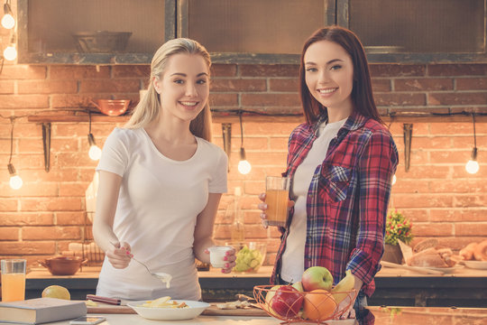 Young Women Friends Cooking Meal Together At Home