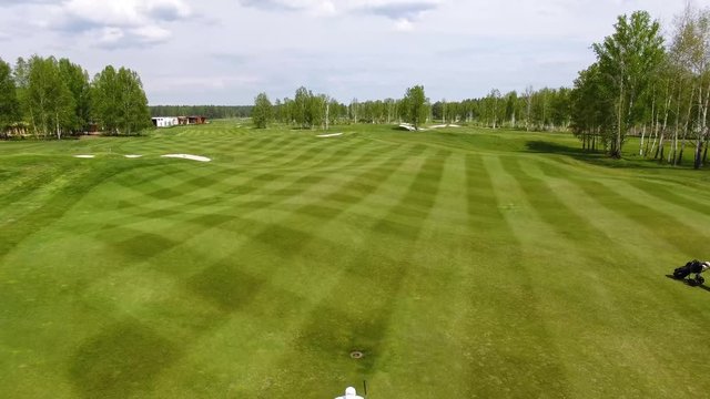 Aerial view Golf course. Golfers walking down the fairway on a course with golf bag and trolley