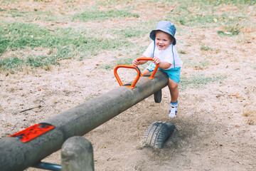 Cute smiling fashionable kid on swing.