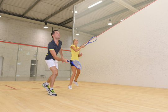 couple enjoying a game of squash in the squash court