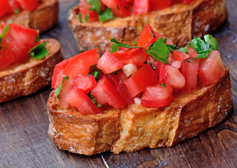 Bruschetta with tomatoes and garlic on wooden table