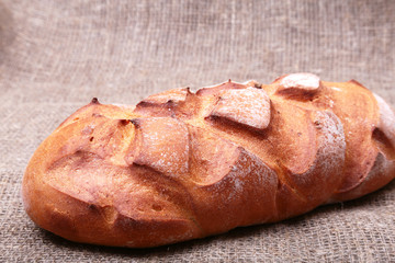 Fresh homemade bread on Sackcloth woven texture background. Selective focus.