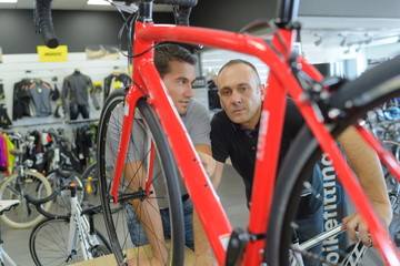 Obraz na płótnie Canvas men discussing bike performances at bicycle shop