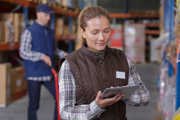 warehouse manager using tablet pc in a large warehouse - obrazy, fototapety, plakaty