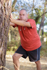 man stretching his arms on the wood