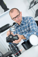 technician engineer checking dslr sensor with magnifying glass