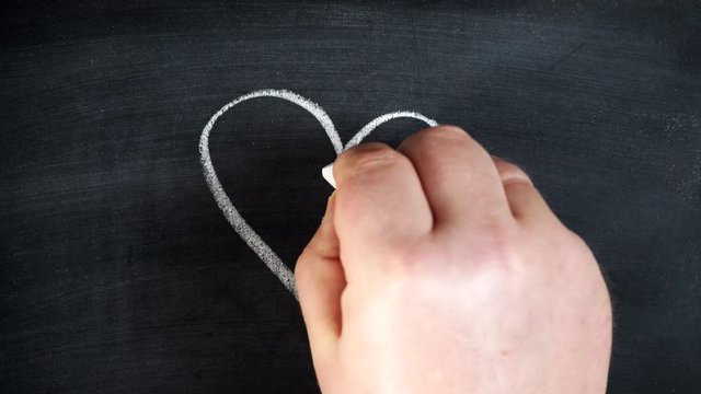 Male hand draw on chalkboard romantic heart shape sign with question mark inside. Doubt in love 4K ProRes HQ codec