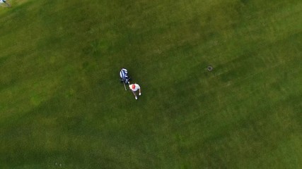 Aerial view Golf course. Golfers walking down the fairway on a course with golf bag and trolley