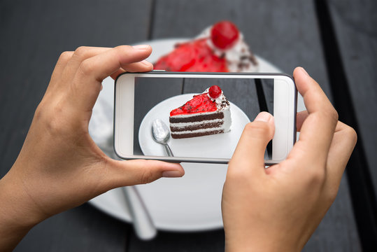 Taking photo of cake on wooden table.