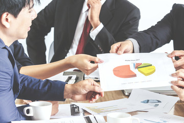 Business people's hands pointing at business document