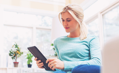 Young woman using her tablet computer at home