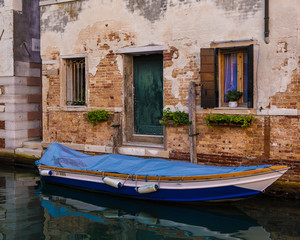 Fototapeta na wymiar Boat in front of old house on canal in Venice