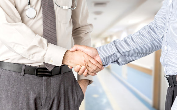 Doctors and businessman shaking hands