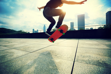 young woman skateboarder skateboarding at city © lzf