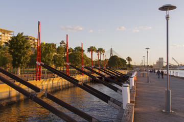 Pedestrians at Darling Island Park wharf in Sydney with the Anzac Bridge in the background