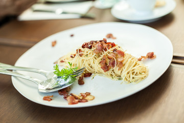 spaghetti becon on white disc in resturant