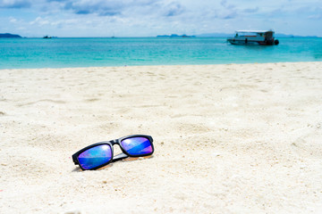 Fototapeta na wymiar Sun glasses on the white sand at the beach of lipe island,turquoise Ocean beach relax, outdoor travel