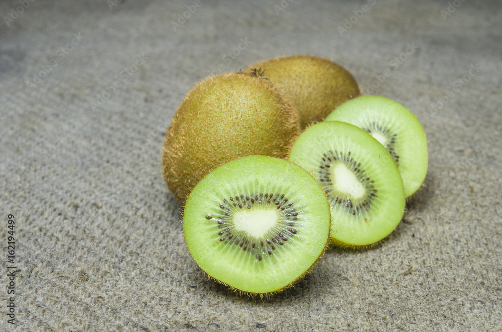 Wall mural ripe whole kiwi fruit and half kiwi fruit isolated put on brown sack