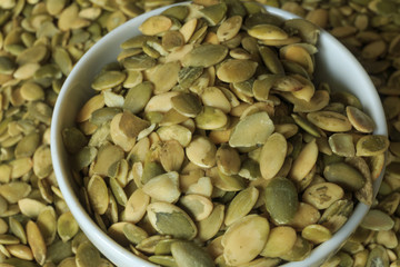 Vegan food. Raw pumpkin seeds for roasting on a wooden table