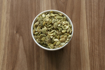 Vegan food. Raw pumpkin seeds for roasting on a wooden table