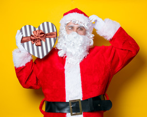 Funny Santa Claus holding heart shape gift