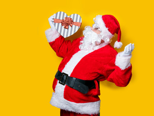 Funny Santa Claus holding heart shape gift
