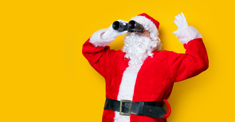 Funny Santa Claus holding binoculars