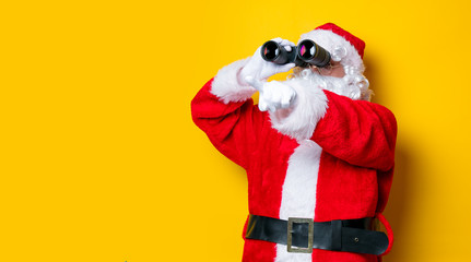 Funny Santa Claus holding binoculars