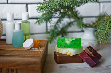 Bathroom accessories. Body care. Multi-colored natural soap, gels, shampoos, balms in vials, sea salt for a bath, a bast. Bathroom cosmetics on a light, white background. Spa treatments with candles
