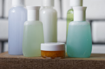 Bathroom accessories. Body care. Multi-colored natural soap, gels, shampoos, balms in vials, sea salt for a bath, a bast. Bathroom cosmetics on a light, white background. Spa treatments with candles