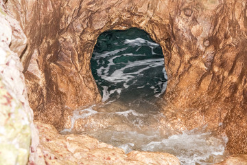 The grotto in the sea-rock during the summer day