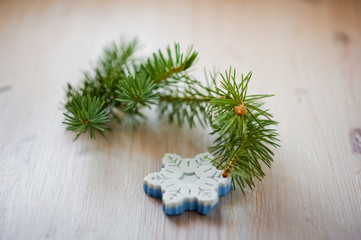 Bathroom accessories. Body care. Natural cosmetic soap in the form of a snowflake and a twig of a Christmas tree. Cosmetic piece of soap on a light white background with pine needles. Spa treatments