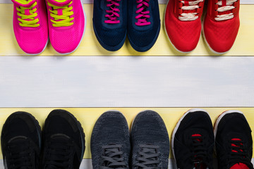 Sets of sports shoes on the wooden floor, as a background for the inscription