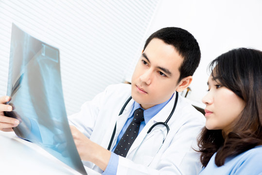 Doctor showing x-ray image to female patient