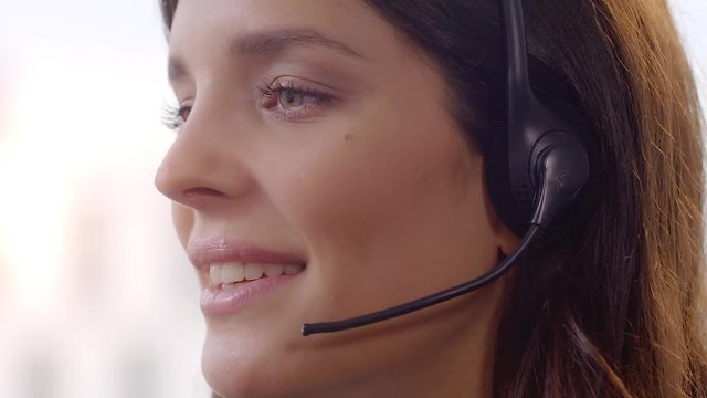 Call Centre Agent with Head Set. Friendly Call Centre Agent working in her office. Shot in 4k with a red dragon down convert to HD.