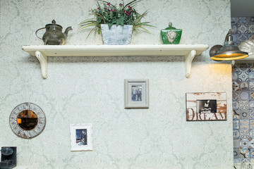 Vintage wall in cafe or restaurant with photos in the frame and a shelf with flowers
