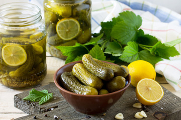 Marinated cucumbers gherkins. Pickles marinated with lemon and garlic on the kitchen wooden table.