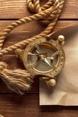 Compass and rope on wooden table. close up