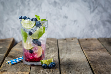 Blueberry mojito in glass on rustic background