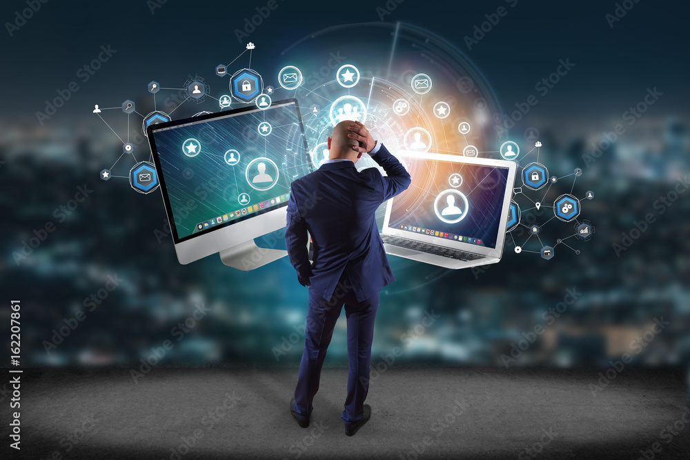 Poster businessman in front of a wall with computer and devices displayed on a futuristic interface with bu